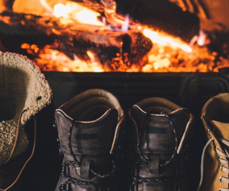 Winter boots warming by the fire