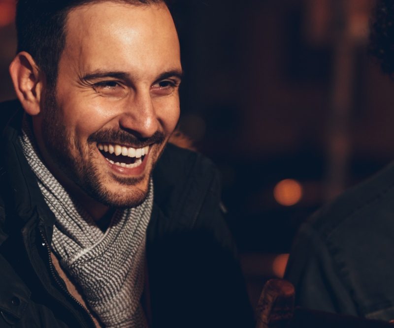 A group of friends in winter wrapped up warm and laughing