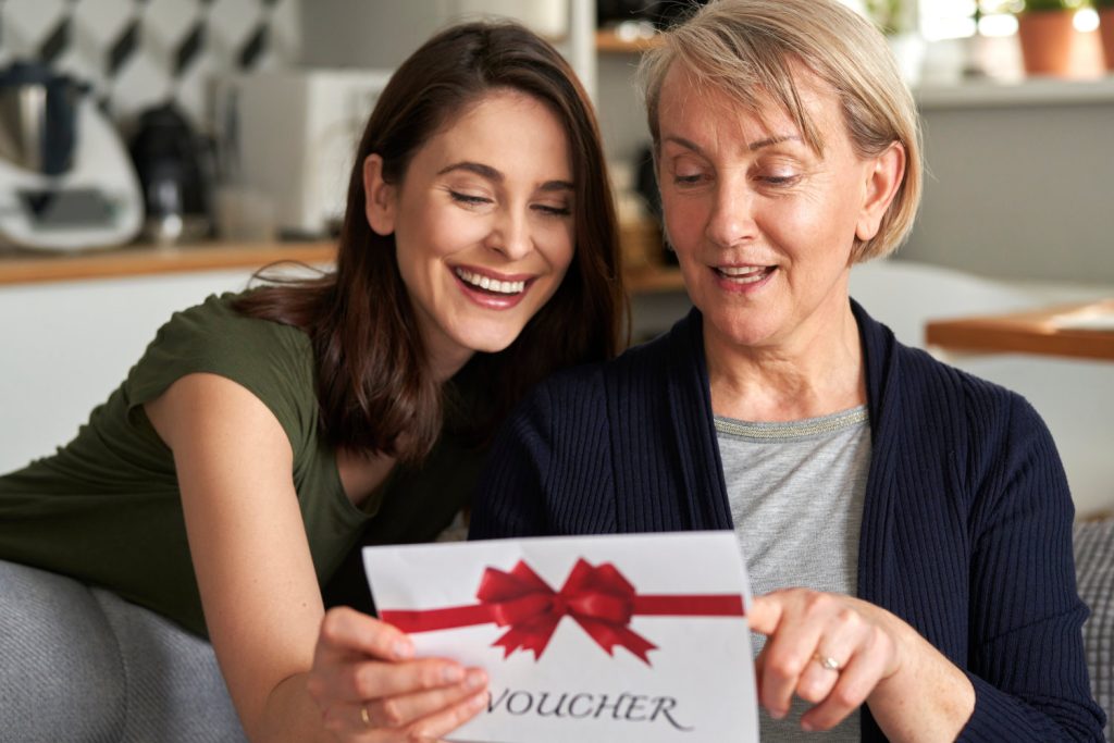 Daughter giving gift voucher to her mother