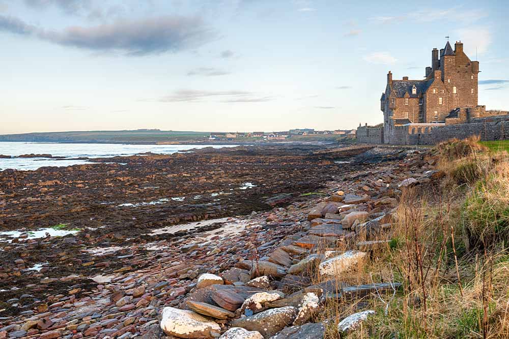 Ackergill Tower next to a beach.