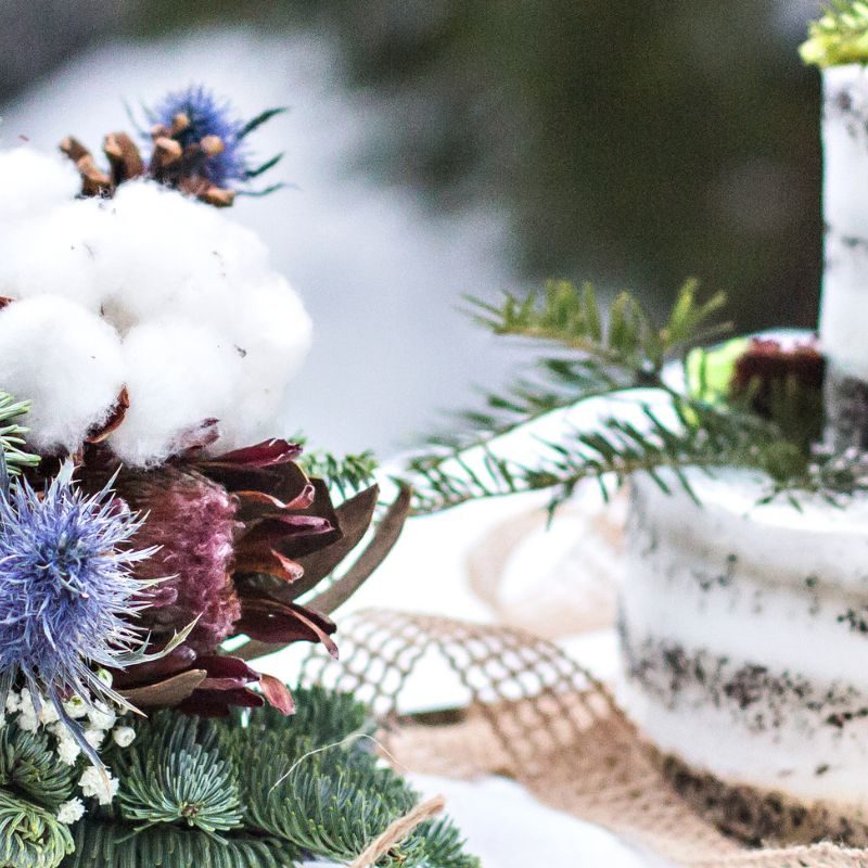 Rustic winter wedding. Table decor. Winter wedding table decor bride and groom for photo shoot. Aerial view of winter green garland on a wedding table with white plates, cake, glasses, champagne.