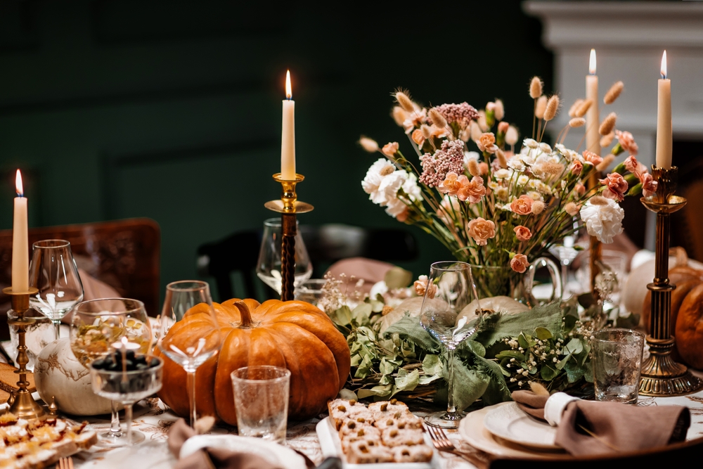 Wedding dinner table. Decoration and serving of the festive table with autumn decor, candles and flowers dishes and pumpkins.