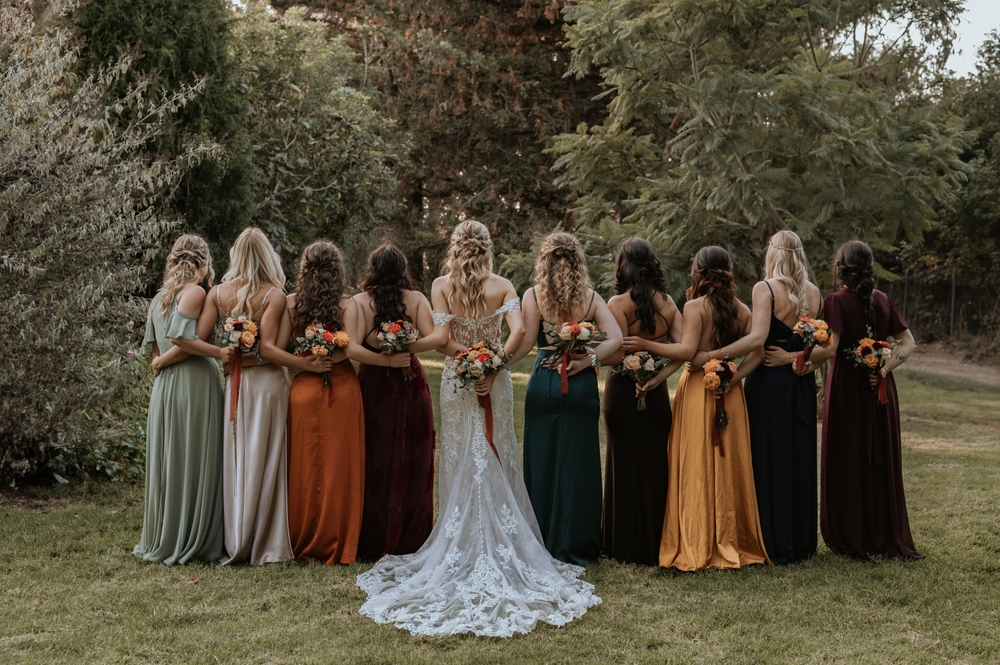 Bride and here bridesmaids on here wedding day taking a group picture hugging.